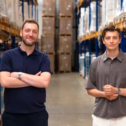 Twee medewerkers in het magazijn van Euralpack, tussen de rekken met verpakkingsmateriaal.