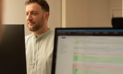 Collega bekijkt de weekplanning in kleurblokken op zijn scherm
