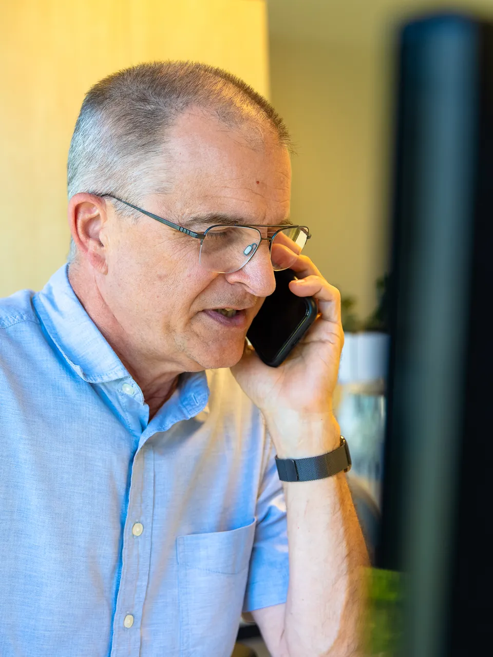 Zaakvoerder aan de telefoon achter zijn bureau