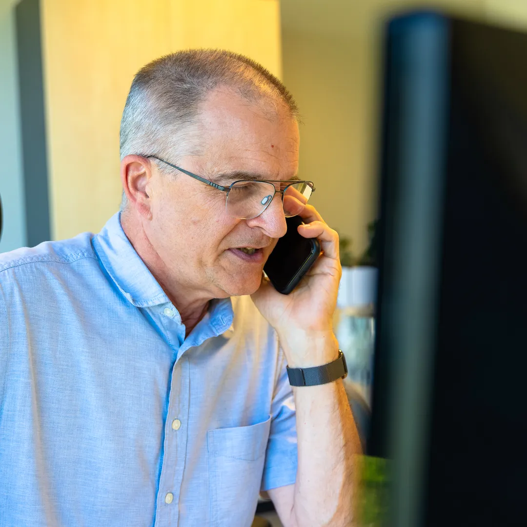 Zaakvoerder aan de telefoon achter zijn bureau